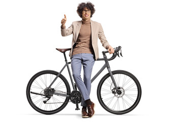 Young man leaning on a bicycle and gesturing thumbs up