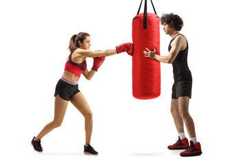 Female practicing box and man holding a punching bag