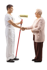 Full length profile shot of a decorator and elderly woman shaking hands