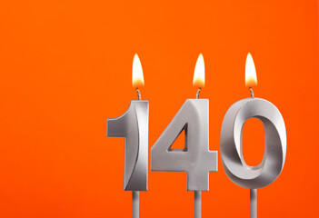 140 candle - Birthday celebration on orange background