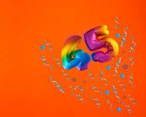 Multicolor balloon number 45 - Confetti explosion on orange background. Birthday card - obrazy, fototapety, plakaty