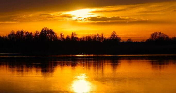 The sky and the lake are red-tinged during sunset, a beautiful sunset on the lake in early spring