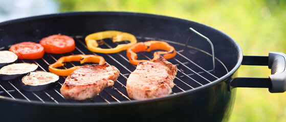 Cooking of juicy meat and vegetables on barbecue grill outdoors, closeup