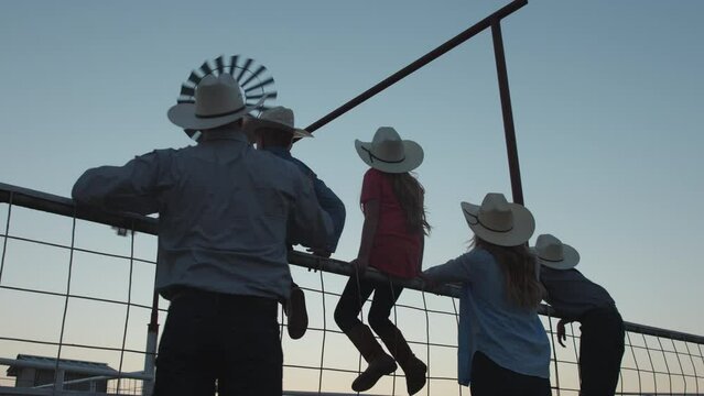 A big family watches the sun set on their farm