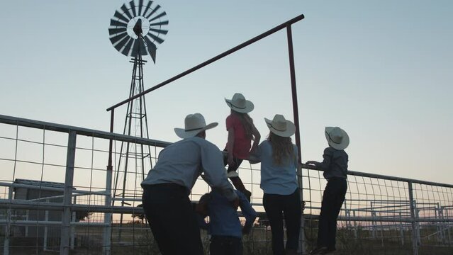 Low angle of a family of farmers watching the sunset