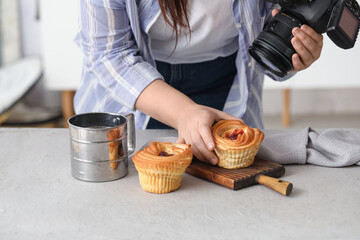 Female food photographer preparing for shooting cakes in studio, closeup
