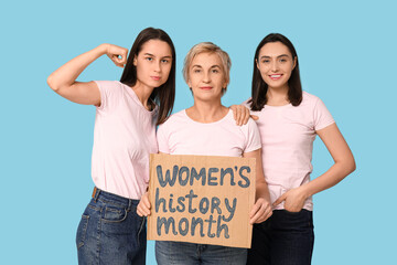 Beautiful women holding cardboard with text WOMEN'S HISTORY MONTH on blue background