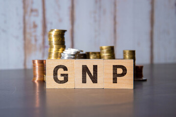 GNP Gross Domestic Product word made with wooden blocks on yellow background.