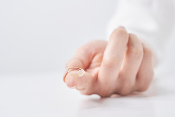 コンタクトレンズを持つ女性の指