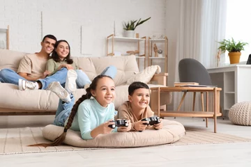 Tuinposter Little children playing video game and his parents at home © Pixel-Shot