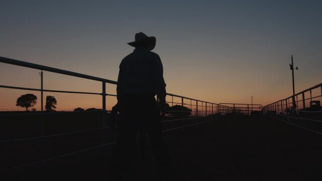 Silhouette shot of a family of farmers walking along a pasture gate