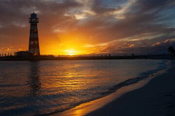 Horizontal shot of a summer dusk. The orange sky with the sun dipping to the horizon behind the...