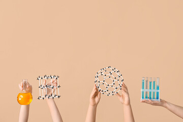 Female hands holding filled flask with test tubes and molecular models on beige background....