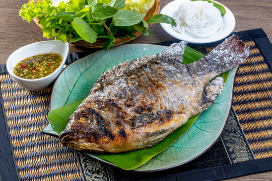 Tilapia grilled with vegetable on a wooden table