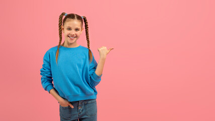 Smiling girl with braids pointing to side