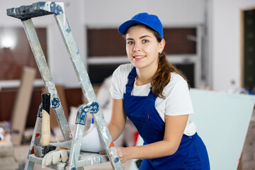 Woman foreman in overalls signs an act of acceptance of completed work
