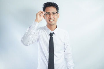 Indoor picture of young business man in glasses pictured isolated on white background looking straight at camera, showing confidence and providing stability for employees