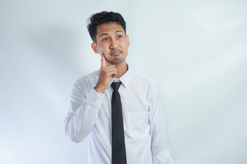 Young Asian man wearing white shirt showing thinking gesture
