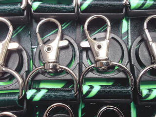 a collection of carbiner hooks with a folded cord and a green pattern. head strap of identity card