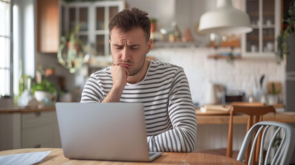 Thoughtful Man Evaluating Work on Laptop at Home