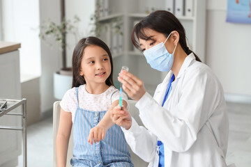 Little Asian girl receiving vaccine in clinic