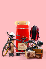 Unwanted stuff for yard sale with bicycle on pink background