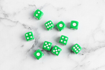 Many green game dices on white marble table, flat lay
