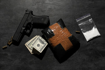 Drug package with money and gun on dark background - obrazy, fototapety, plakaty