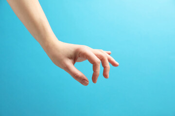 Woman holding something in hand on light blue background, closeup
