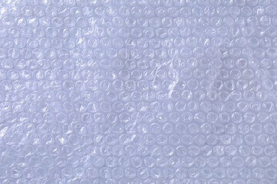 Transparent bubble wrap on gray background, top view