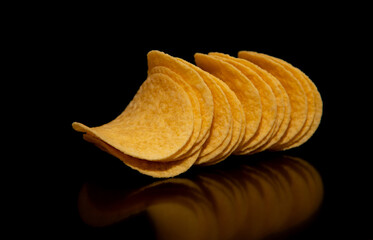 Close-up with a group of potato chips on a black background, perfect as a decorative or ornamental image