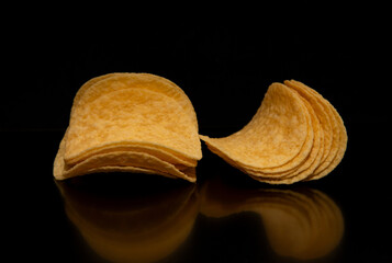 Close-up with potato chips on a black background