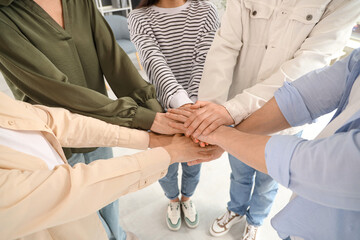 People putting hands together at group therapy session, closeup