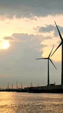 Wind turbines in Antwerp port on sunset. Antwerp, Belgium. Camera pan