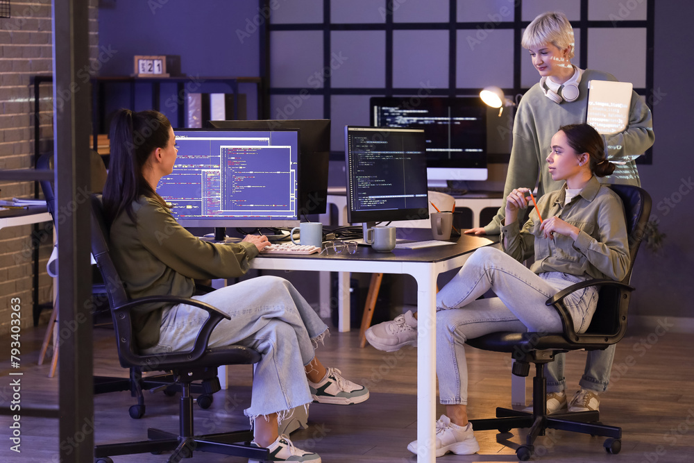 Poster Group of female programmers working in office at night