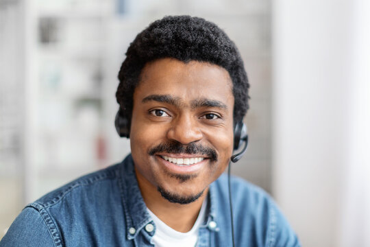 Friendly black guy with headset smiling at camera