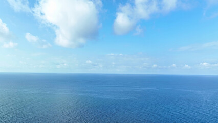 From above, behold the endless sea, adorned with rhythmic waves, under the vast embrace of blue...