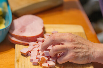 Women hands close up dicing ham for cooking 