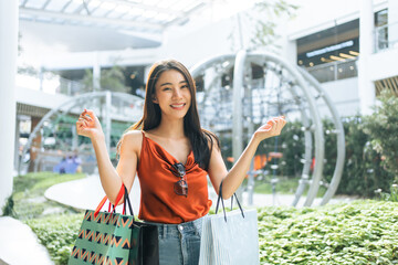 Portrait of Asian woman shopping goods outdoor in department store. 