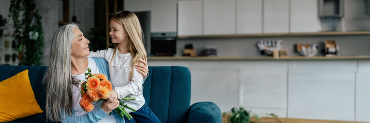 Cheerful little girl hugs european elderly lady