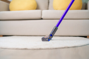 Woman cleaning Carpet with cordless Vacuum cleaner. Housewife using wireless Vacuum for big cleaning home. Housework, Housecleaning, Housekeeping, Removes dust, Domestic hygiene and daily routine