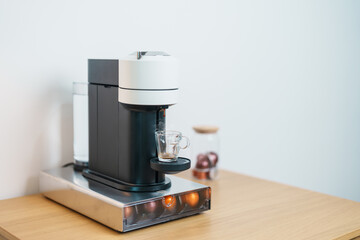 Espresso Coffee Maker Machine with Capsule of roasted coffee bean on wood table bar. Daily beverage drink at Home, Apartment and Office concept