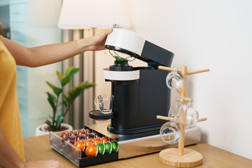 hand making Espresso Coffee by Coffee Maker Machine with Capsule of roasted coffee bean on wood...