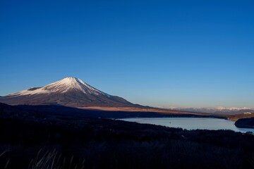 展望台から見た朝日を浴びて輝く富士山と山中湖のコラボ情景