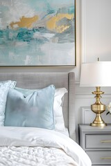 A closeup shot of the bedside table in an elegant bedroom, featuring soft white and blue accents with golden lamp details