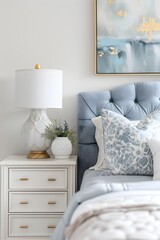 A closeup shot of the bedside table in an elegant bedroom, featuring soft white and blue accents with golden lamp details