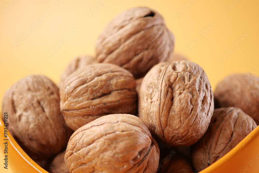 Wall mural natural walnut in a bowl on yellow background  - Wall murals