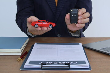 Fototapeta premium Businessman with car insurance documents. He is a male. Car insurance protects his vehicle. Documents are papers that show important information.