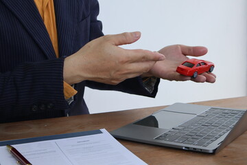 Businessman with car insurance documents. He is a male. Car insurance protects his vehicle....