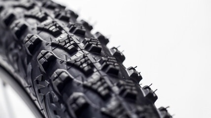 Close-up of a mountain bike tire tread showing detailed texture against a white background.